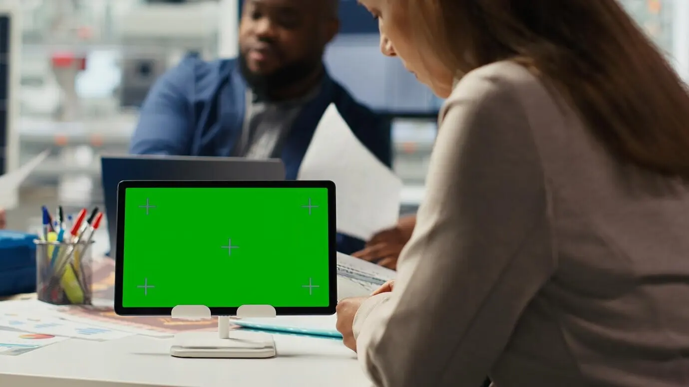 Акционеры фотовольтаического завода анализируют рыночные тенденции на макетном планшете.