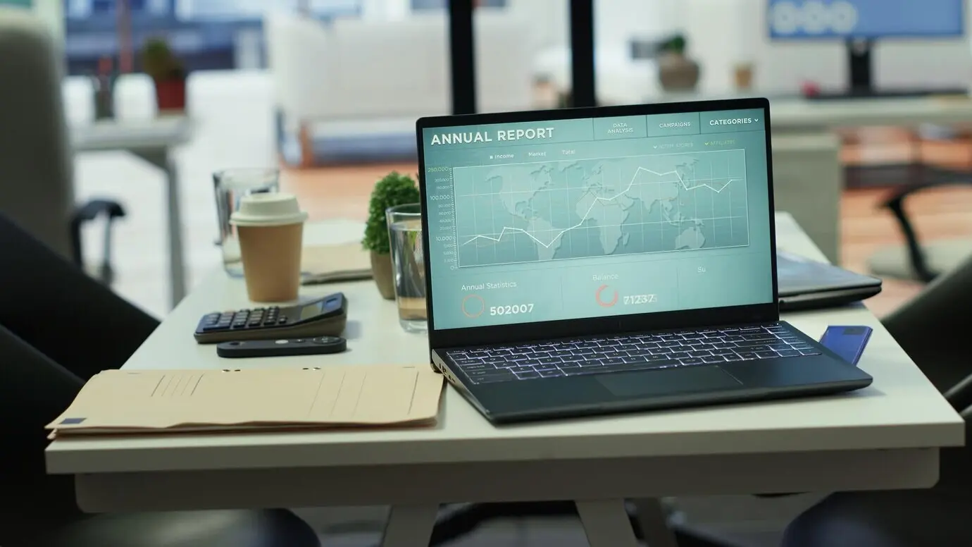 Престижный офис компании с компьютером, на котором отображаются подробные аналитические данные, и деловыми встречами руководителей.