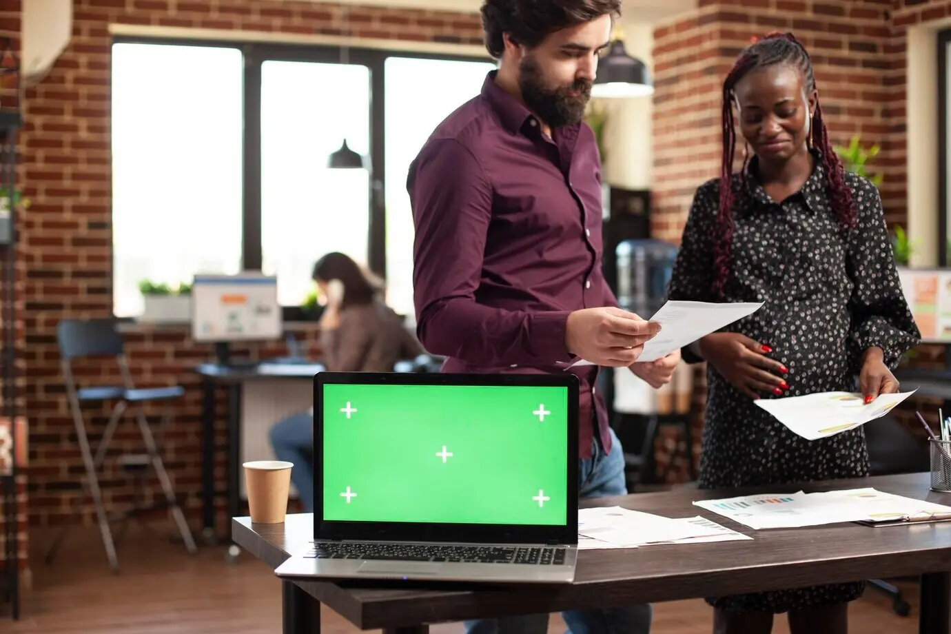 На столе — ноутбук с зелёным экраном.